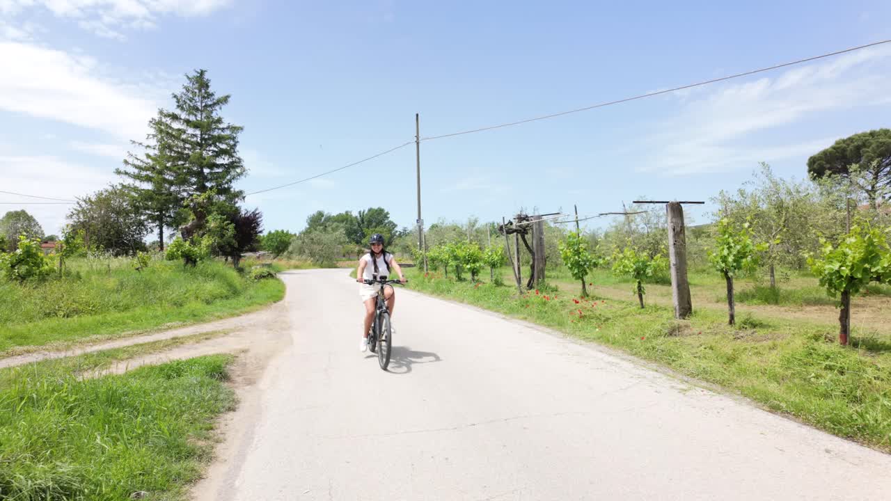 Woman Cycling through a Picturesque Italian Vineyard