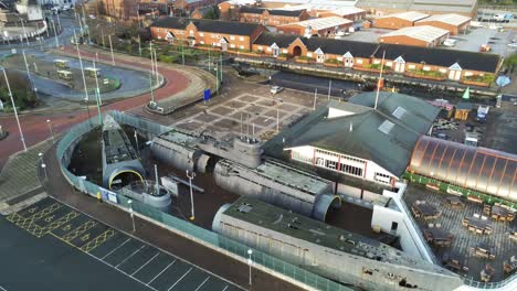 Woodside-ferry-village-terminal-aerial-view-above-Birkenhead-dismantled-naval-ship-harbour-skyline-pigeons-fly-through-shot-rising-dolly-right