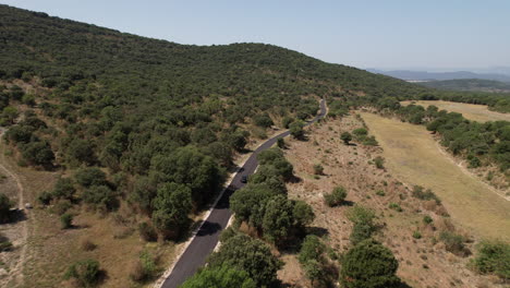 coche eléctrico negro conduciendo en una carretera de campo vacía al sur de francia