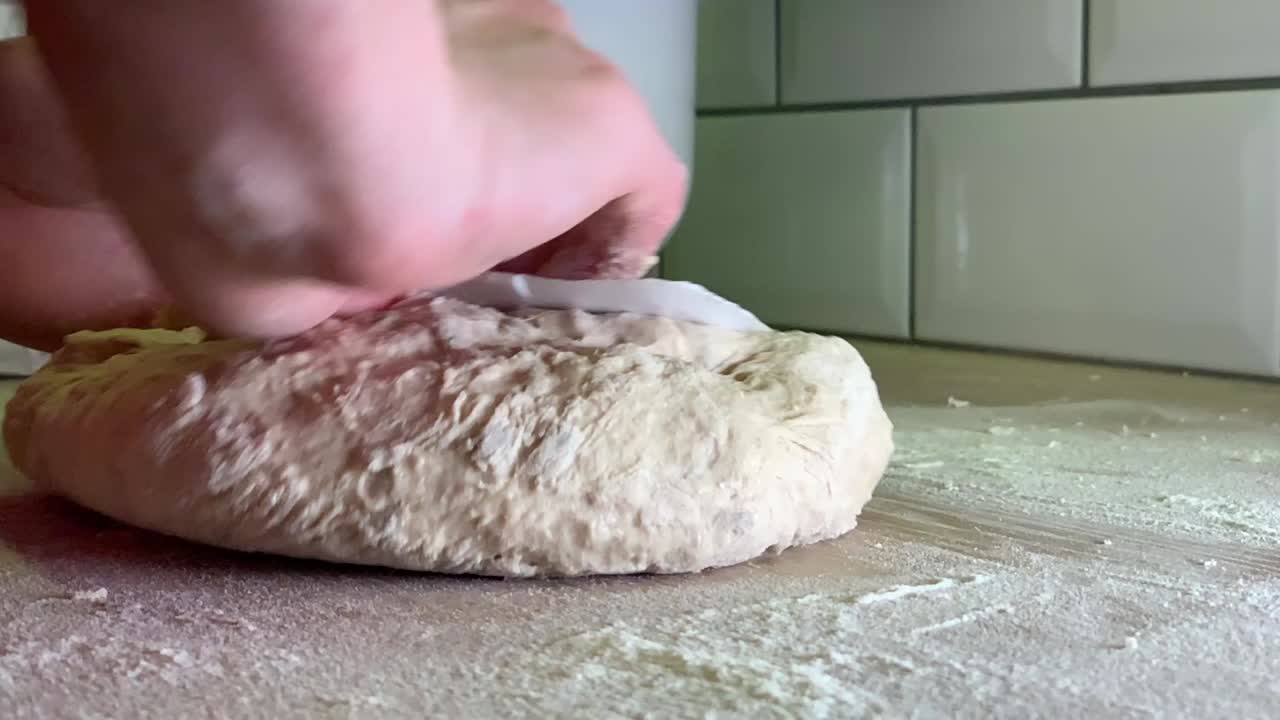 Mani femminili che lavorano l'impasto appiccicoso per il pane con una spatola di plastica a casa