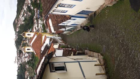 traveler walks down narrow cobbled slope between historic buildings in ouro preto, mg, brazil