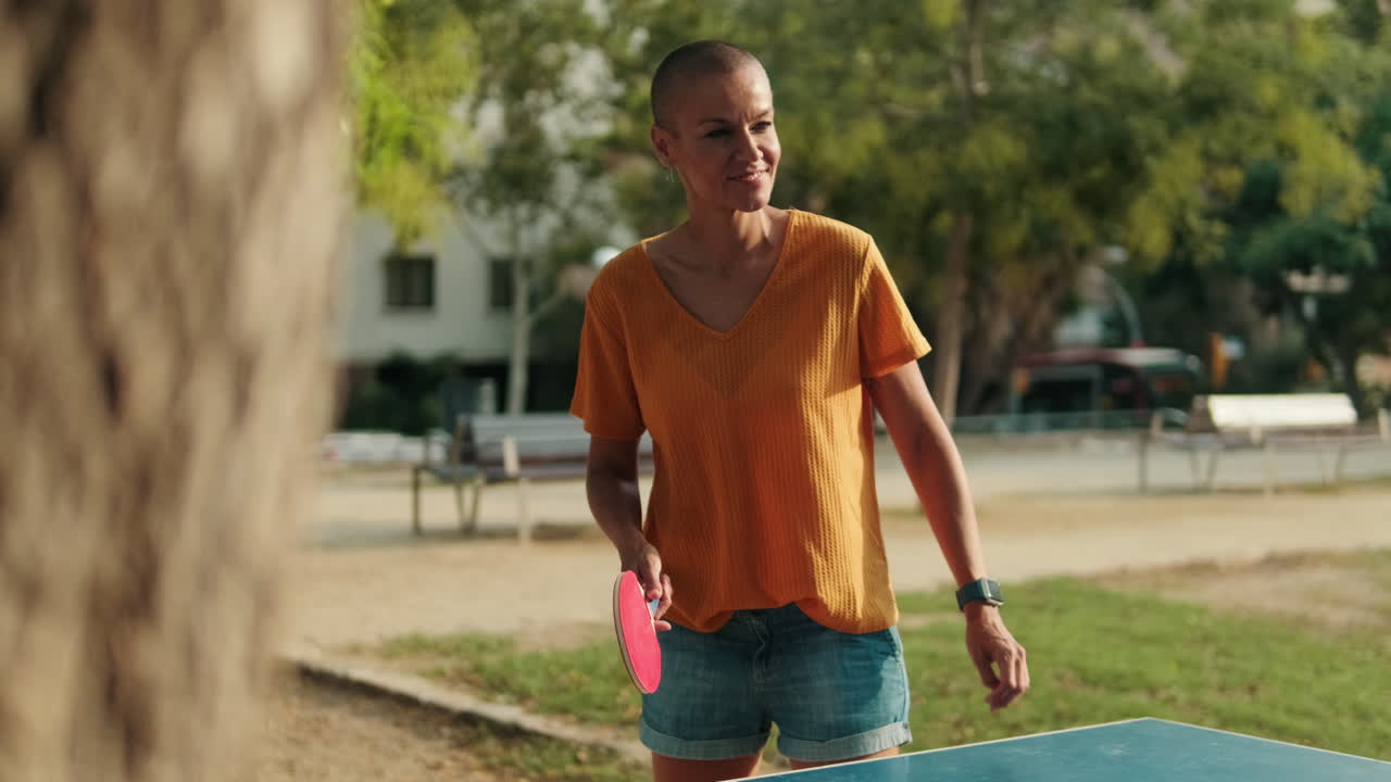 Mother and daughter playing table tennis in the park