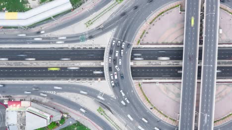 time-lapse of car traffic transportation above roundabout road. drone aerial top view. public transport or commuter city life concept, panning