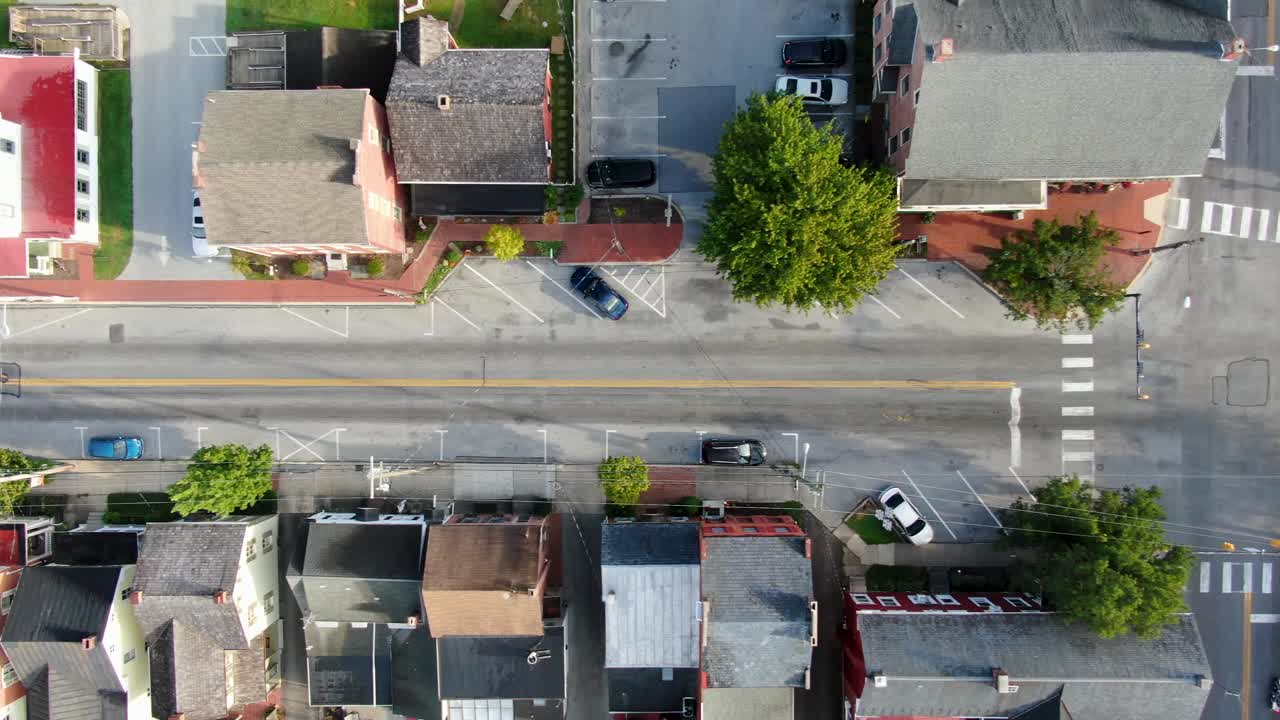 Aerial top-down birds eye drone view of cars at 4-way street intersection at traffic light in USA