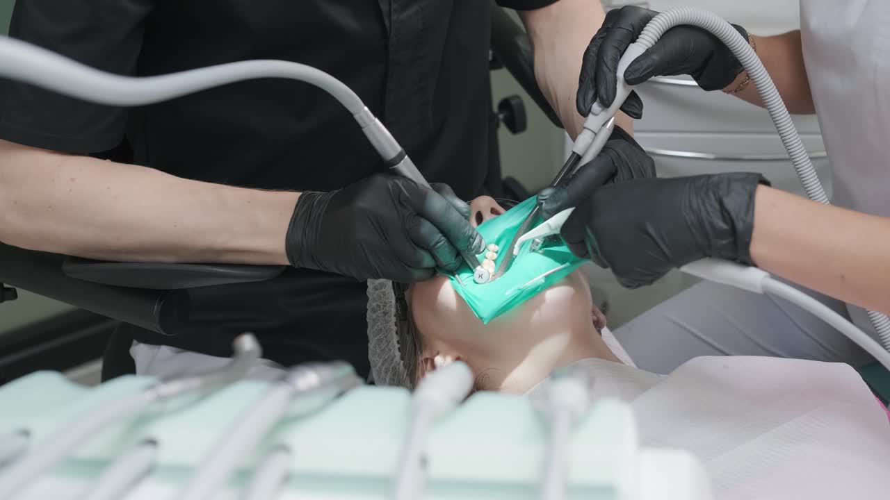 치과의사가 치과의사에서 환자의 치아를 검사합니다.