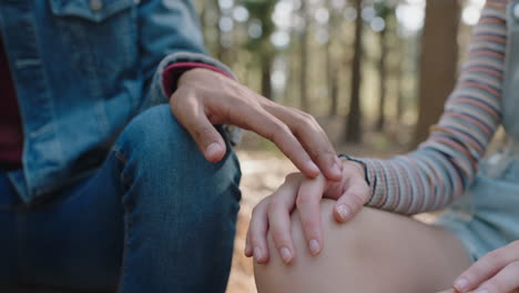 young man playfully touching womans hand with fingers romantic couple sitting in forest woods teenage lovers concept