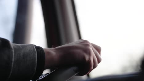 extreme close up of hands on steering wheel driving forward a semi truck