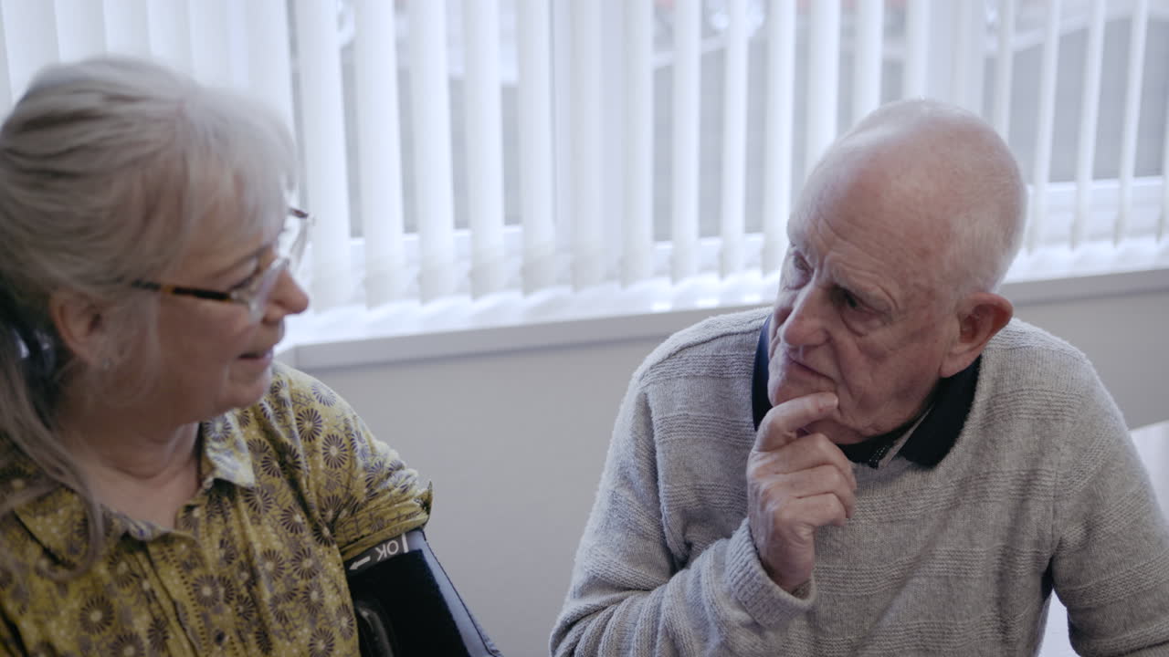 Elderly couple checking blood pressure at home