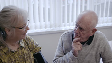 elderly couple checking blood pressure at home