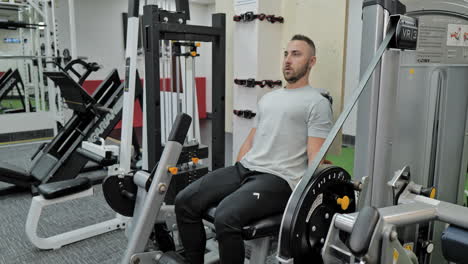 hombre musculoso entrenando activamente en el gimnasio moderno