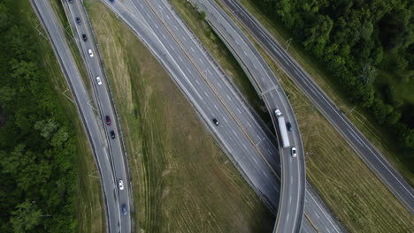 aerial view following a semi-truck driving on a highway, cloudy day in canada