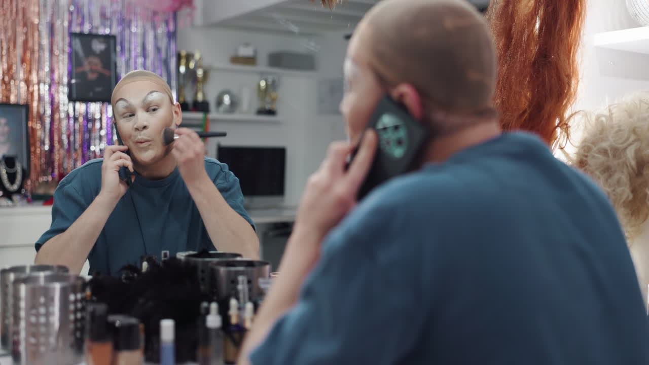 Drag queen applying makeup while on a phone call