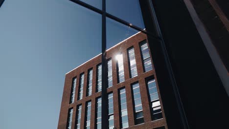 the glass of the building reflects the city's business architecture. sun rays in the city