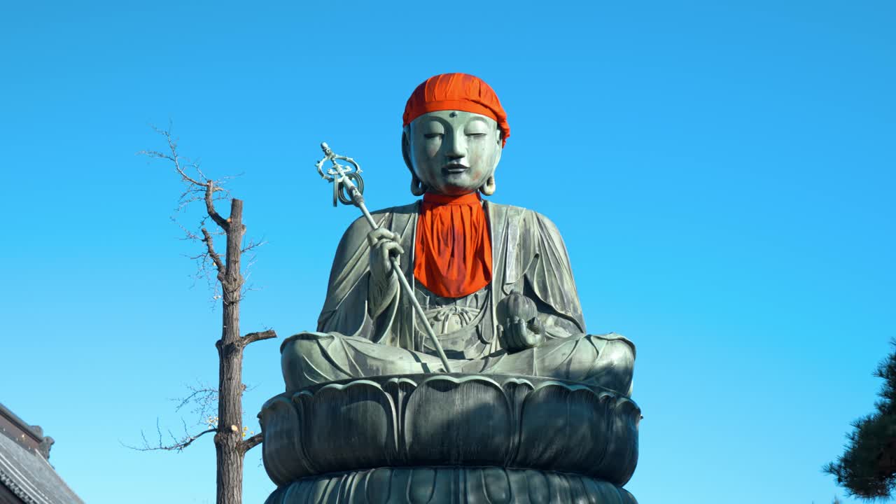A serene and peaceful scene of a Buddha statue outside a traditional Japanese temple.