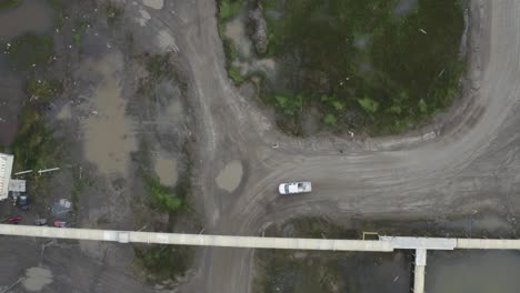drone aéreo de arriba hacia abajo disparado volando sobre la inundación centro de investigación climática en la tundra de permafrost descongelado cerca de barrow alaska con furgoneta y hombre caminando
