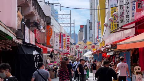 busy japanese street market with colorful storefronts and people walking under a clear sky