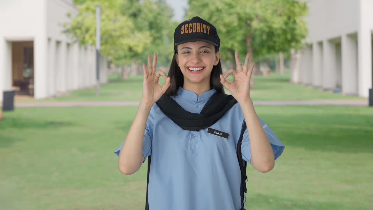 una guardia de seguridad india feliz mostrando una señal de que está bien