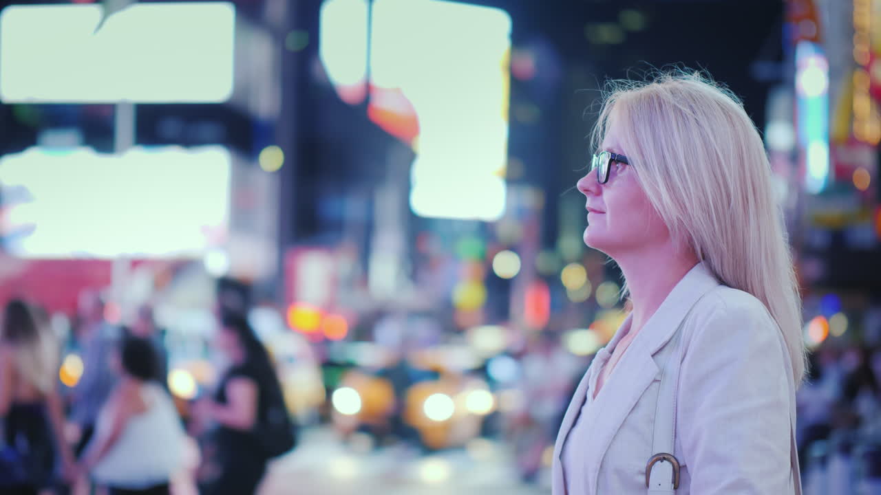 뉴욕 노란 택시가 지나가는 유명한 타임 스퀘어의 불빛을 감상하는 매력적인 여성 -