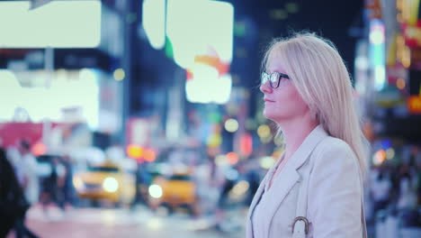 mujer atractiva admirando las luces de la famosa plaza del tiempo en los taxis amarillos de nueva york pasando -