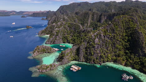 aerial view of philippines coron island’s dramatic coastline, featuring vibrant blue seas, sandy beaches, and dense greenery. with bungalows.