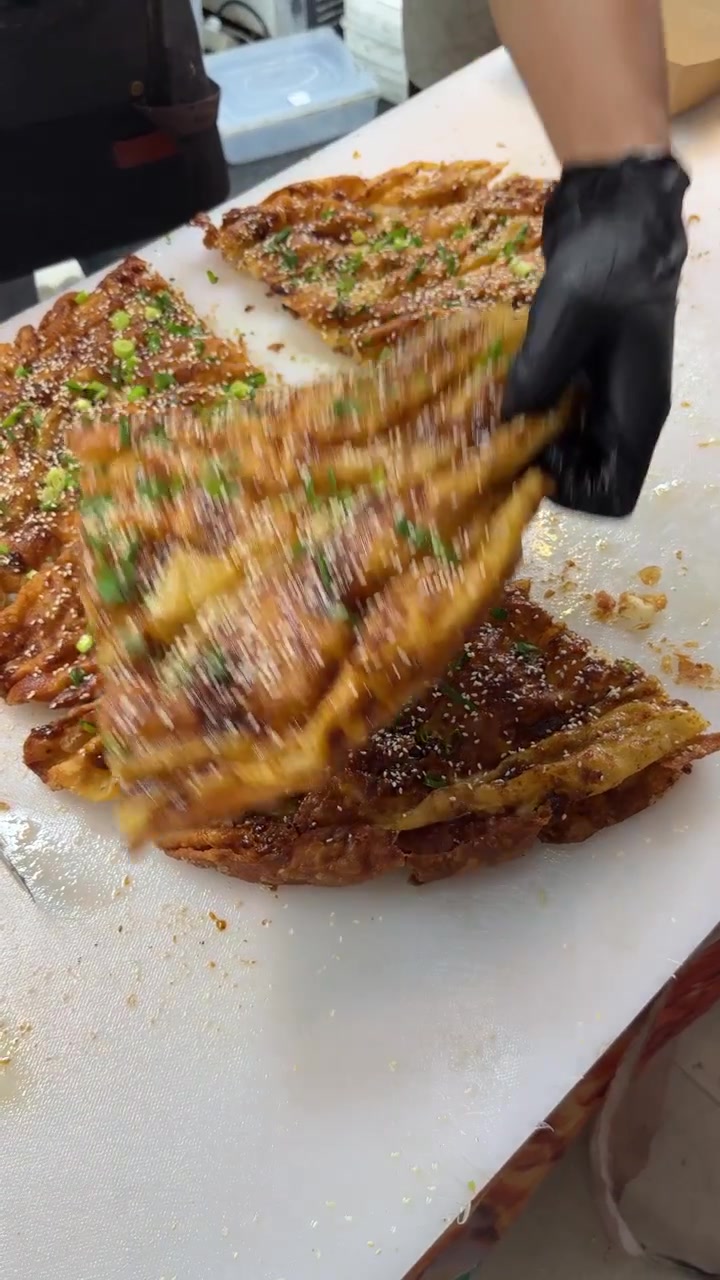 Chef Cortando Panqueca Frita Crocante com Cebolinha e Sementes de Gergelim