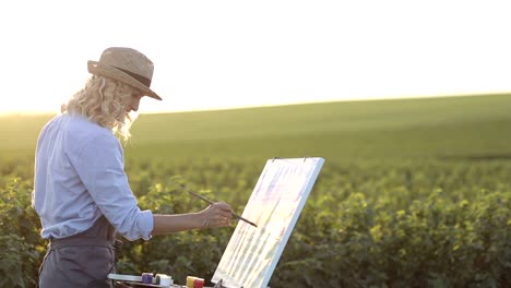 artist girl paints a picture outdoors