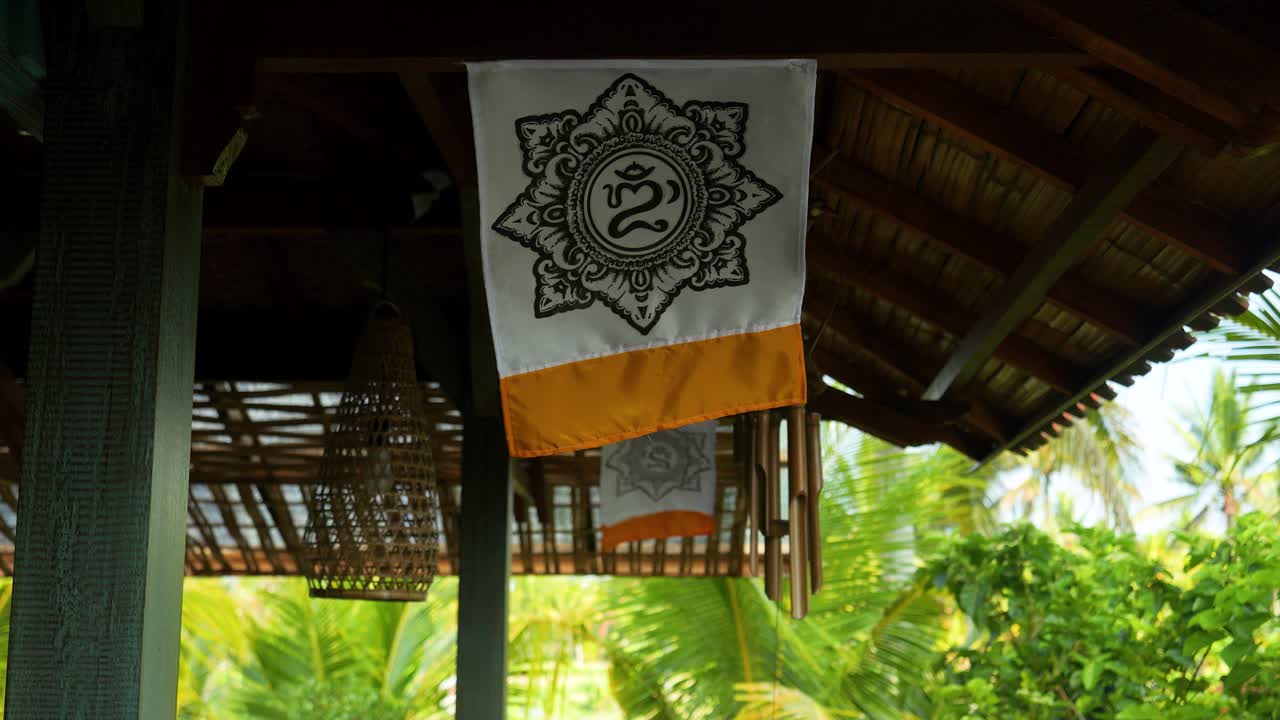 om ritual mandala toch colgado en un poste de madera en bali soplando en el viento en cámara lenta durante un viaje de verano a través de indonesia