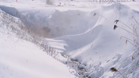 Arroyo-Que-Fluye-En-El-Campo-Cerca-Cubierto-De-Nieve-En-Saint-Jean-sur-richelieu,-Quebec,-Canadá