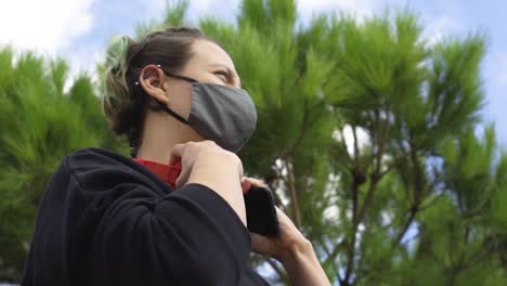 woman looks at mobile and puts on red headphones slowly