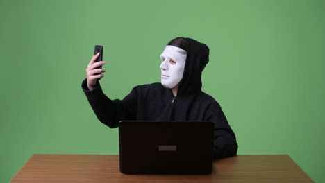 joven adolescente hacker de computadoras contra el fondo verde