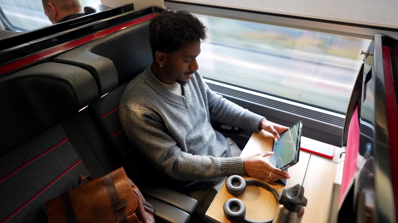 Man working on tablet while traveling by train