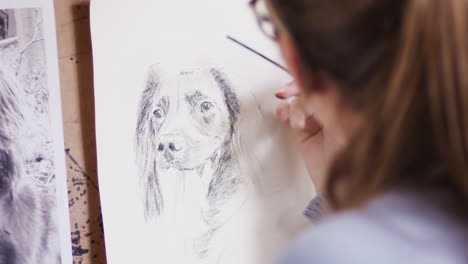 Close-Up-Of-Artist-Sitting-At-Easel-Drawing-Picture-Of-Dog-In-Charcoal