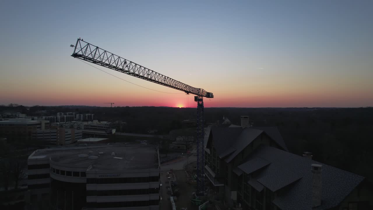 tiro de drone de grúa de construcción girando en el sol de la mañana