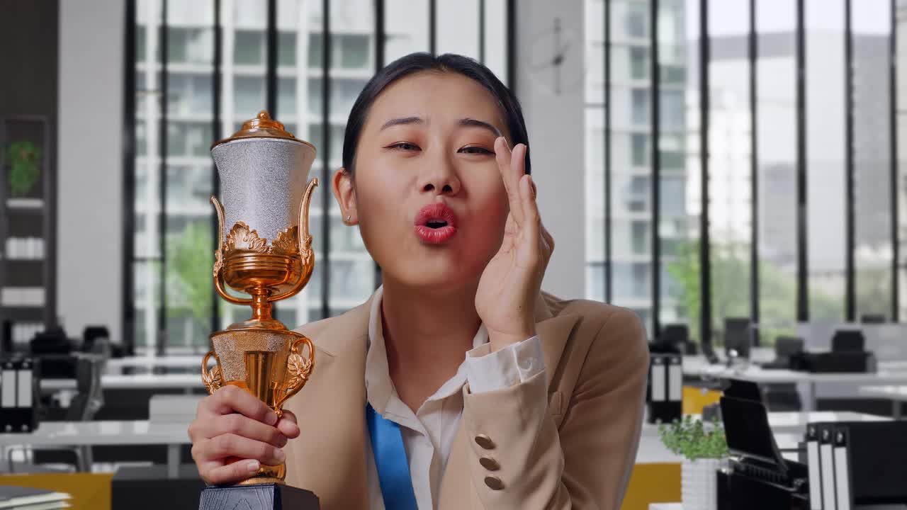 Woman Celebrating a Trophy Win in the Office