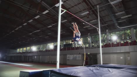 pole vault jumping: professional male athlete running with pole successfully jumping over bar and landing on his feet. stylish focus on sportsman colors, cinematic slow motion of sport achievement