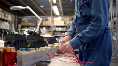 Blue-dressed-electrician-wiring-a-huge-electric-board-in-slow-motion