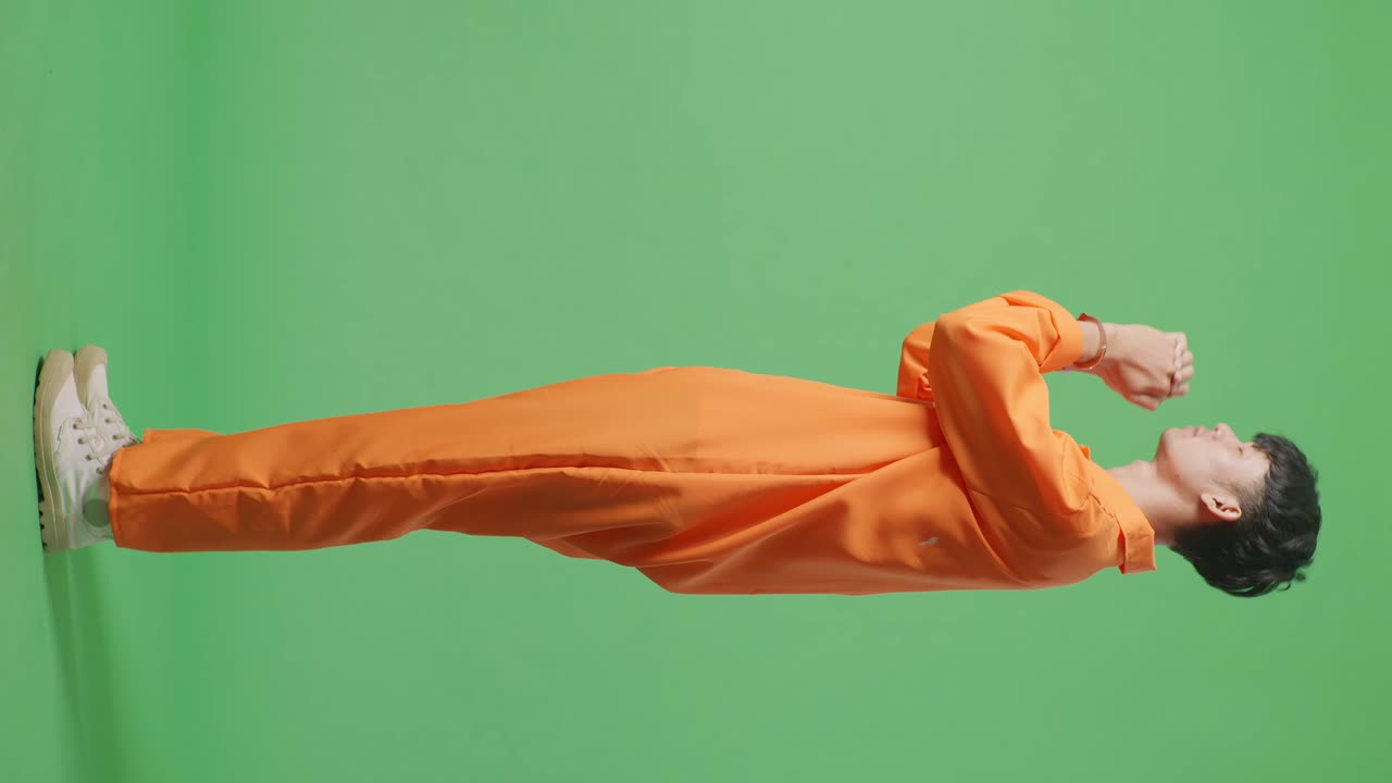 손을 은 아시아 남성 죄수가 녹색 스크린 배경에 서서 무언가를 위해 기도하는 전체 몸의 측면 시각