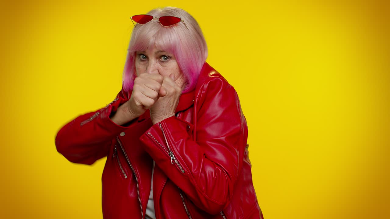 смешная старшая бабушка женщина пытается бороться в камеру, тряся кулаком, бокс с выражением наказания