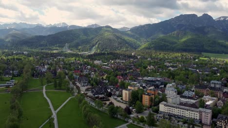 sobrevuelo de zakopane, polonia, un pueblo turístico con arquitectura goral tradicional cerca de las montañas polacas tatra, tierras de cultivo, bosques, pico giewont y gran salto de esquí krokiew - 4k de seguimiento hacia adelante