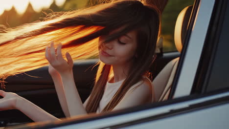 woman with flowing hair enjoying a car ride at sunset