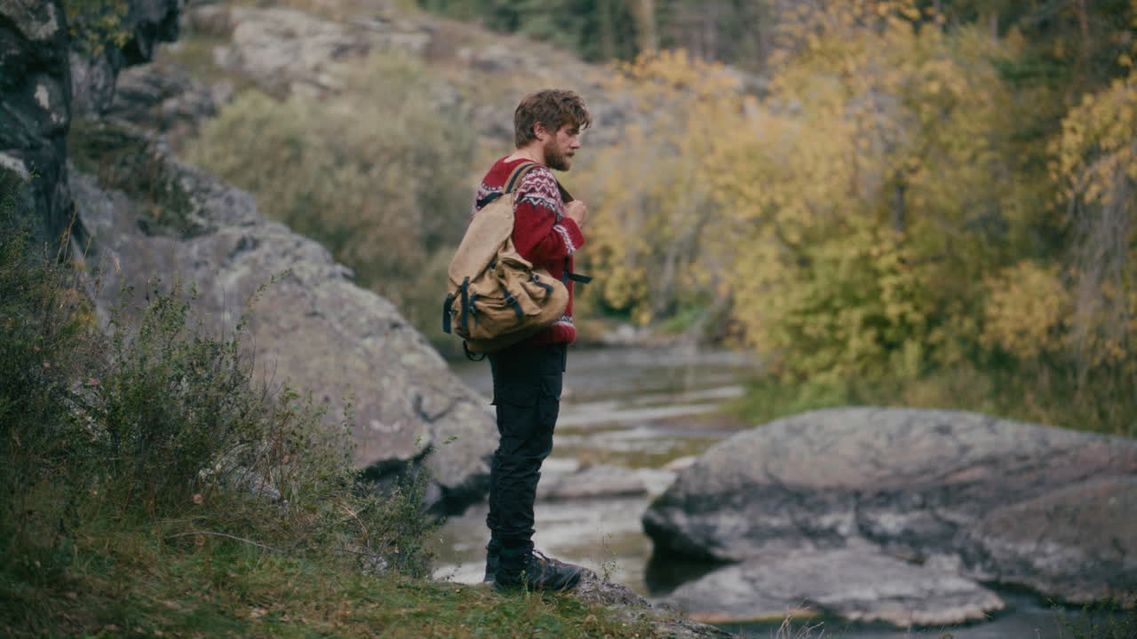 Hiker Enjoying Scenic Nature, then Walking along Riverbank in Autumn Forest