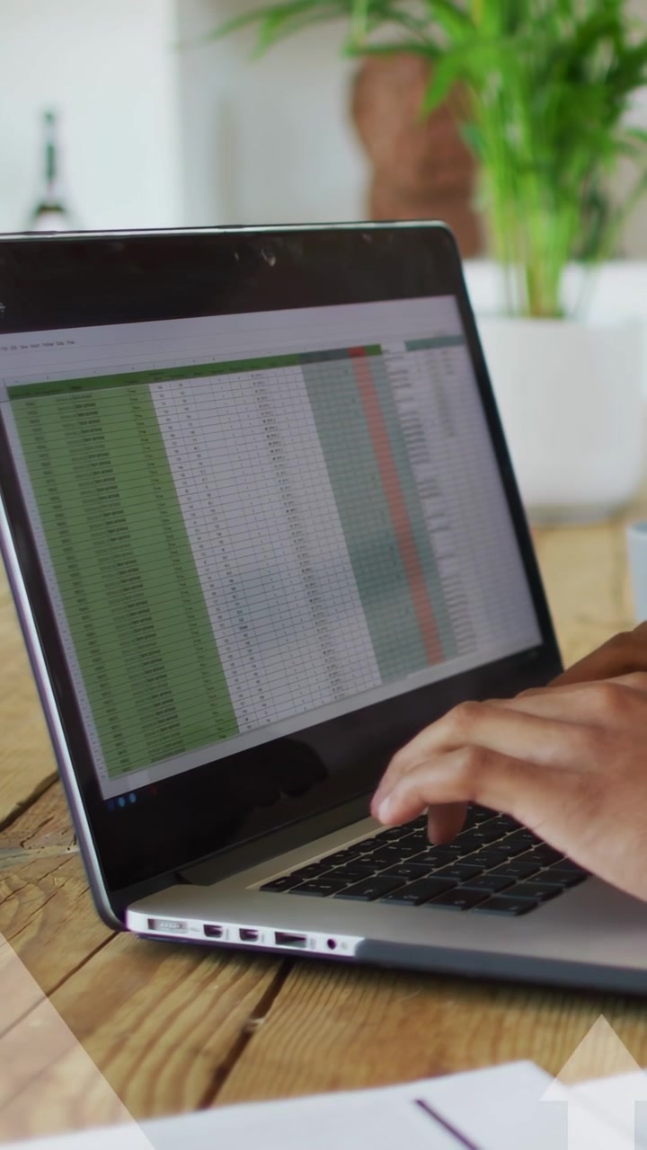 Video vertikal: Pria mengetik spreadsheet di laptop, menyebabkan panah ke atas menunjukkan keuntungan finansial.