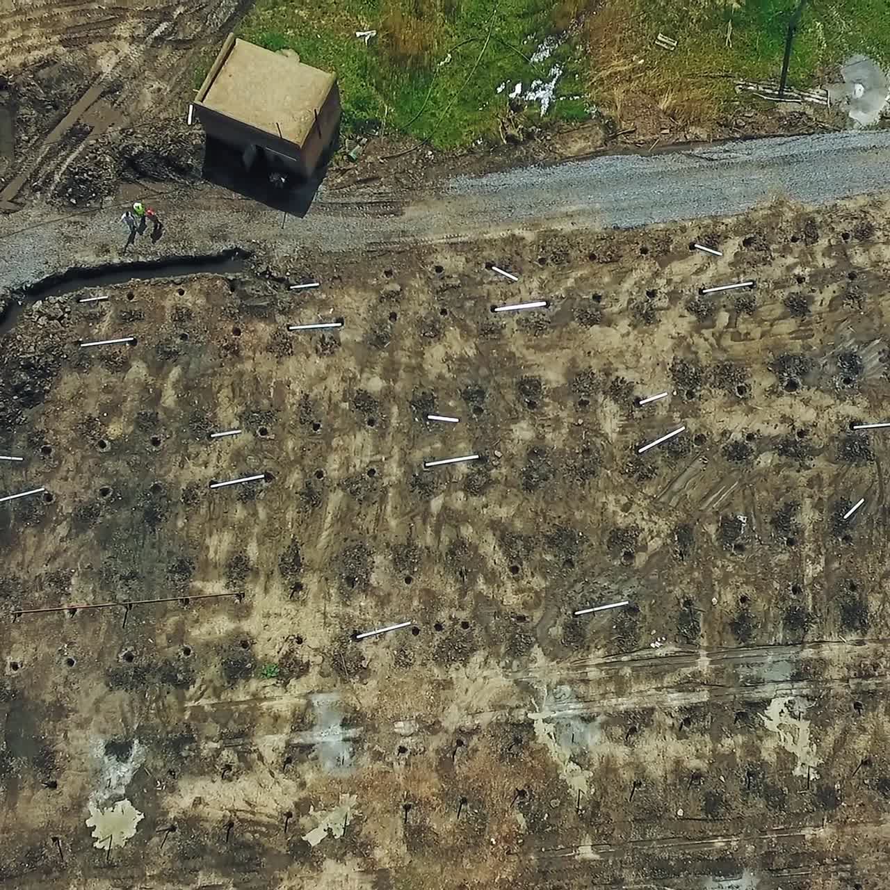 Filas de agujeros en el suelo para la instalación de construcciones metálicas. Zona preparada para una futura planta fotovoltaica de energía verde. Vista aérea