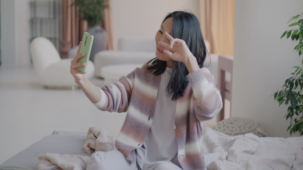 침실에서 셀피를 찍는 여자