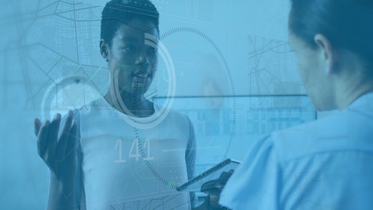 Animation of data processing over two diverse women discussing over a digital tablet at office