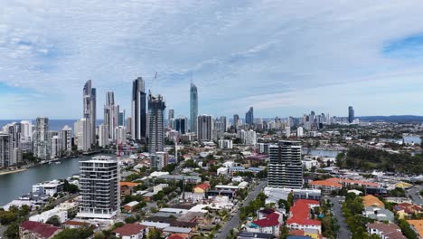 high-resolution drone footage rises above gold coast, australia, revealing modern skyscrapers, waterways, and urban landscape under bright daylight with smooth upward camera movement