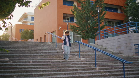 tourist walking down stairs at evening sunlight. woman exploring urban district