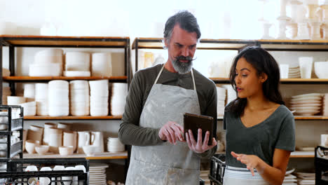 male and female potter using digital tablet 4k