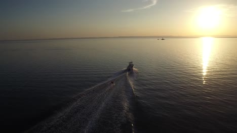 aerial shot of inflatable towable pull by a small boat in the sunset, sea of cortez, baja california sur