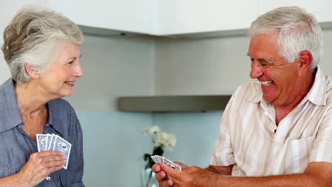 Senior-couple-playing-cards-at-the-counter